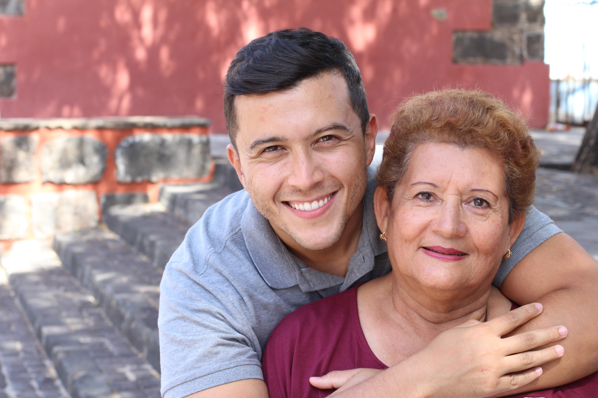 Mother and son smiling outdoors.